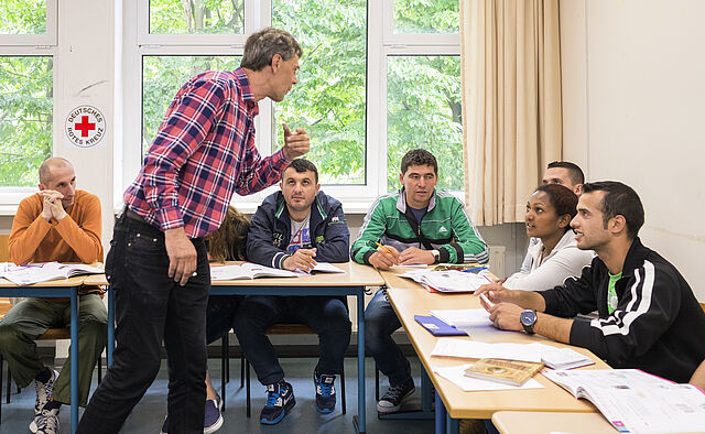 Mitarbeiter des DRK unterrichtet in einem Deutschkurs für Flüchtlinge 